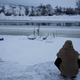 A man sits by the Cannon Ball River at the Oceti Sakowin camp where thousands have gathered to protest the Dakota Access oil pipeline near Cannon Ball, N.D., Wednesday, Nov. 30, 2016. Photo via AP